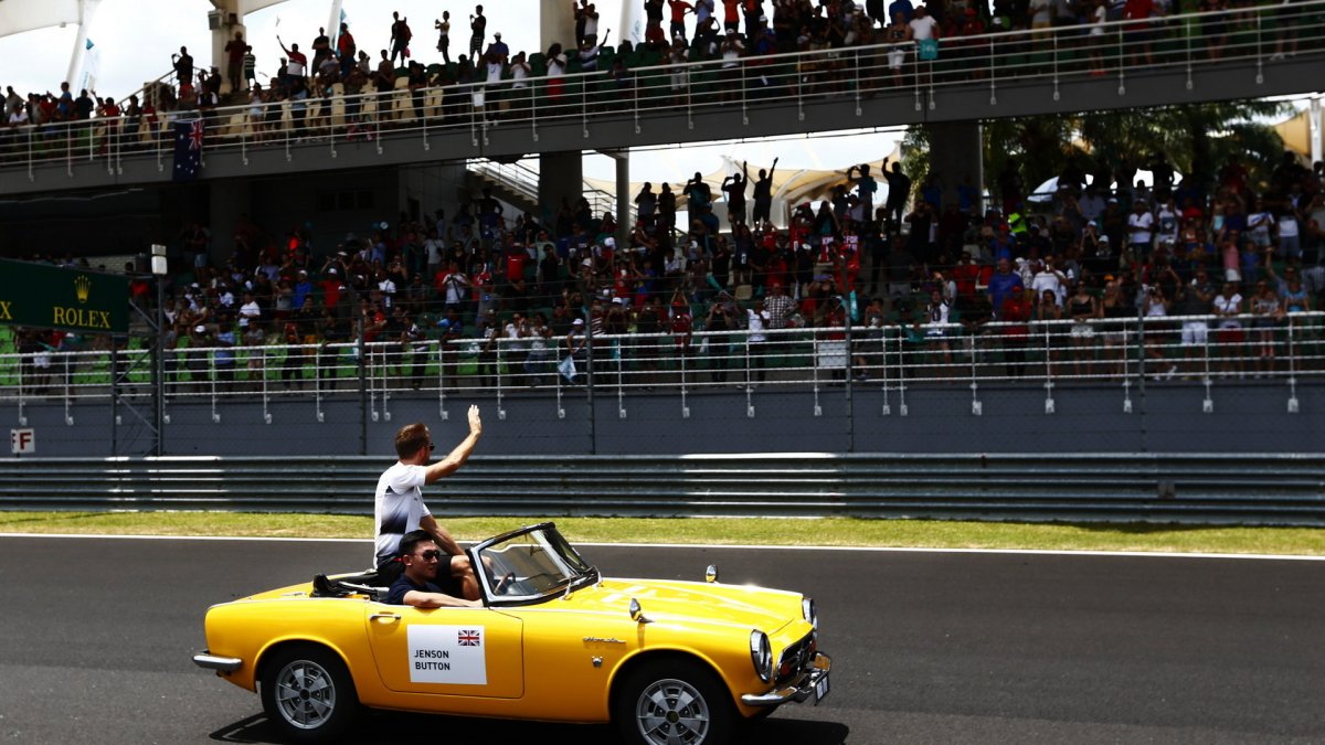 Jenson Button před závodem mává divákům