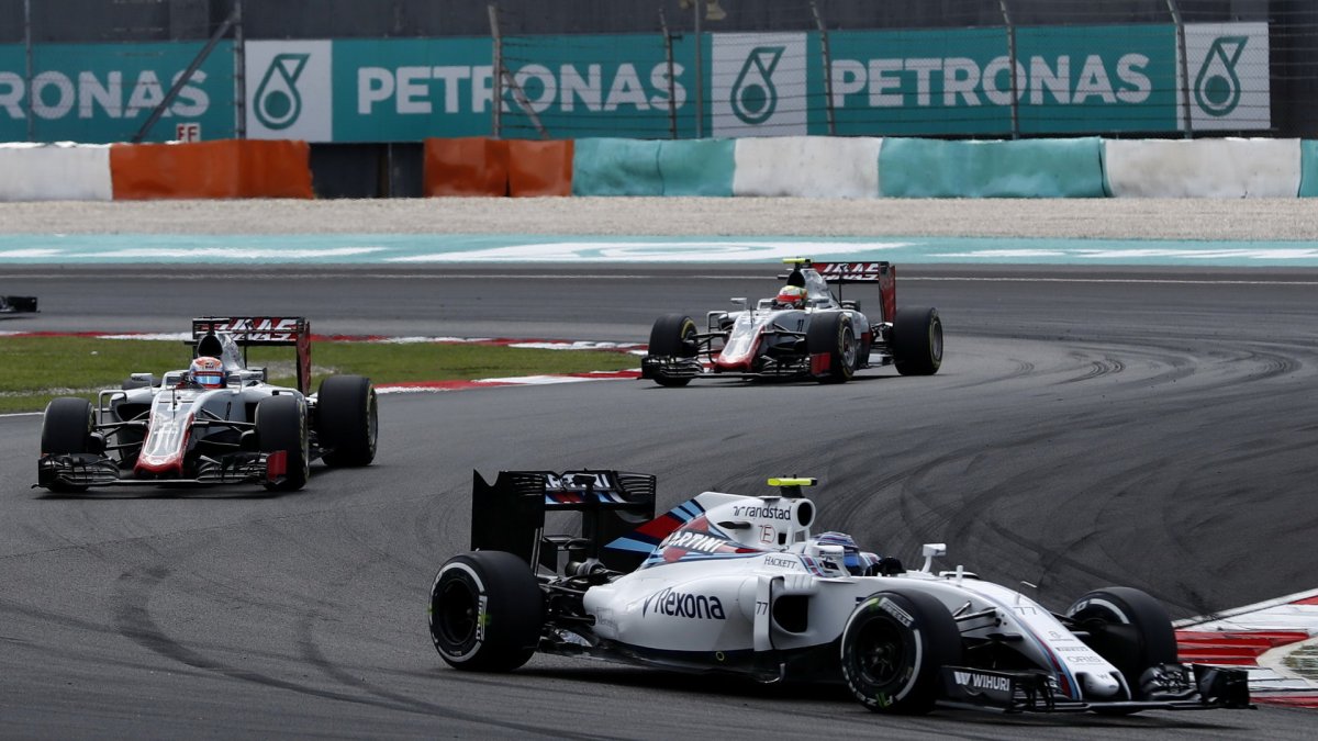 Valtteri Bottas před vozy Haasu v závodě v Malajsii