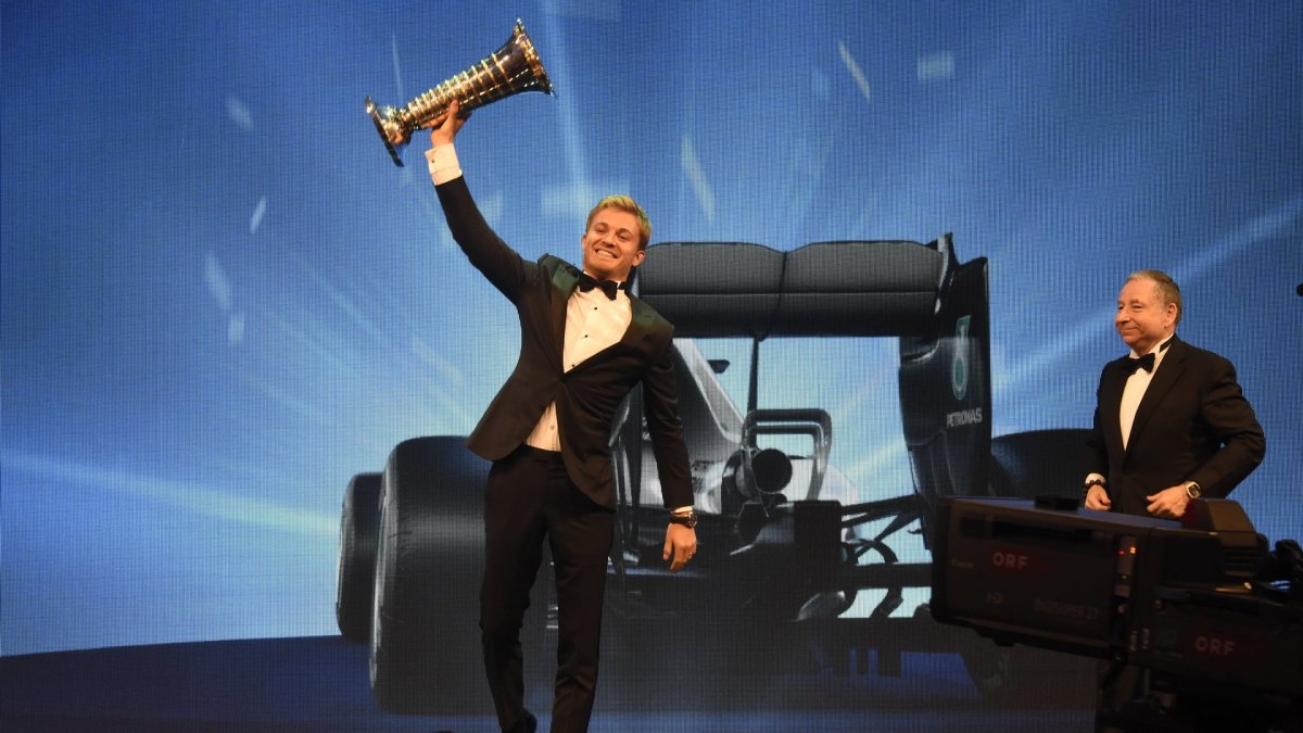Nico Rosberg se raduje se svou mistrovskou trofejí, v pozadí Jean Todt