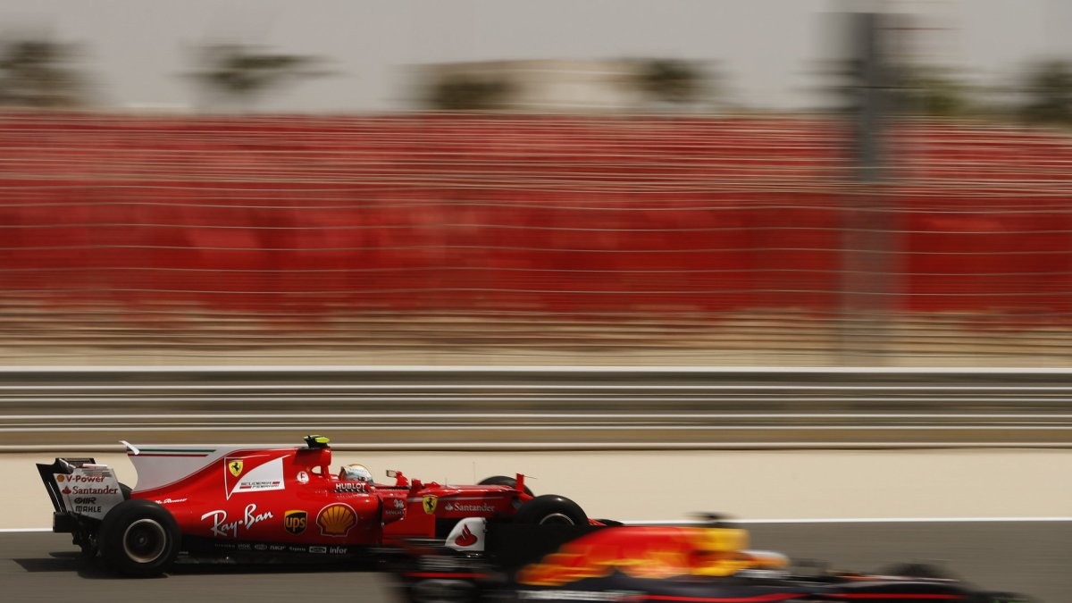 Sebastian Vettel předjíždí vůz Red Bull při sezónních testech v Bahrajnu