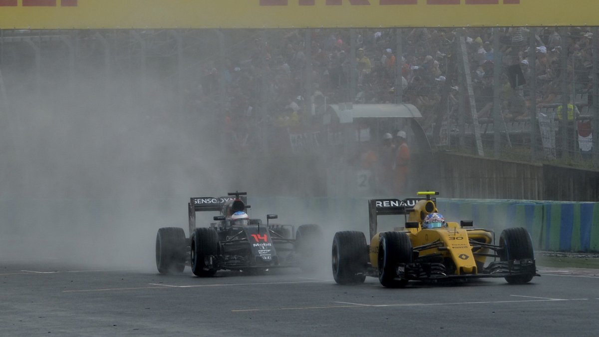 Jolyon Palmer a Fernando Alonso při sobotní deštivé kvalifikaci v Maďarsku