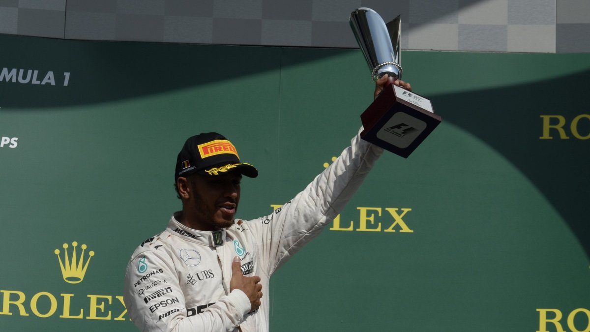 Lewis Hamilton se svou trofejí na pódiu po závodě v Belgii