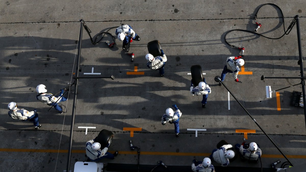 Mechanici se připravují na výměnu pneumatik při pátečním tréninku v Malajsii