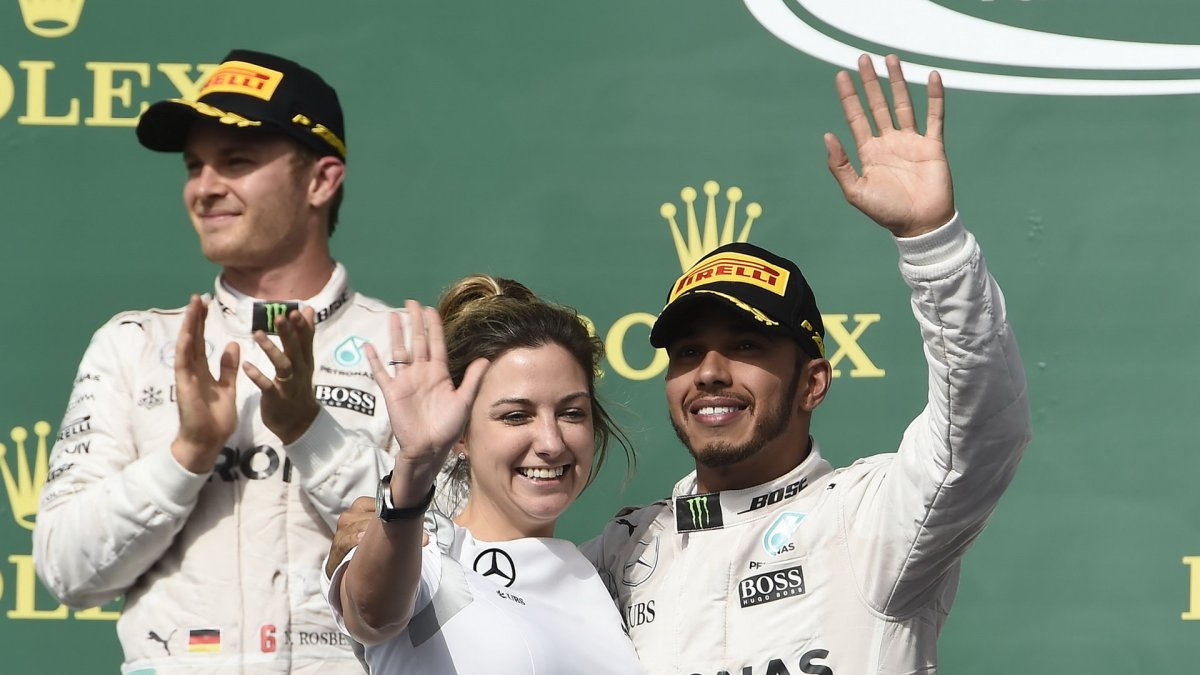 Lewis Hamilton se raduje s Nicem Rosbergem a s Victorií Vowlesovou na pódiu