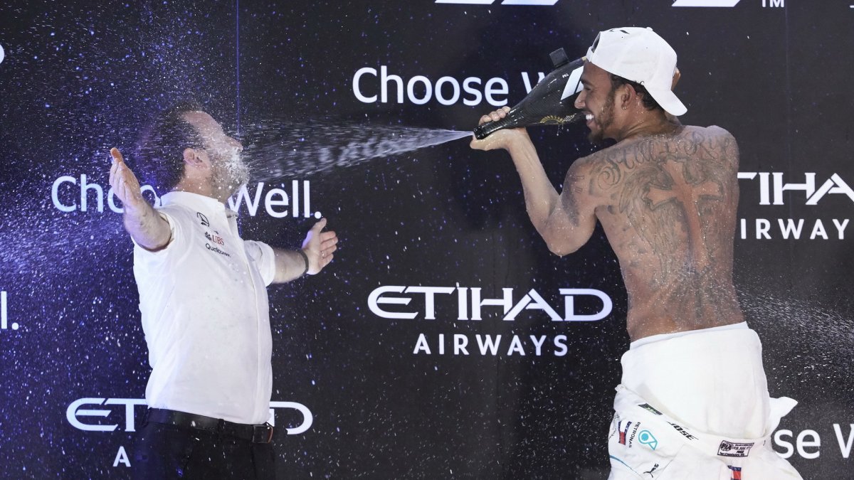 Lewis Hamilton slaví na pódiu po závodě v Abú Zabí
