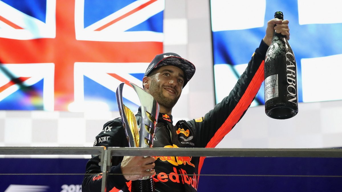 Daniel Ricciardo na pódiu se svou trofejí po závodě v Singapuru