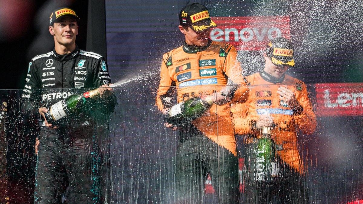 George Russell, Oscar Piastri a Lando Norris slaví v Maďarsku 2025.